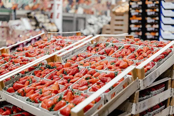 Holzsteigen mit Erdbeeren in Pappsschalen, leicht schräg aufgestellt zum Verkauf in der Großmarkthalle